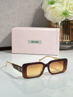 MiuMiu sunglasses with dark red-brown square frames and gold-toned metal arms
