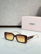 MiuMiu sunglasses with dark brown square frames and gold-toned metal arms