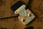 Louis Vuitton small bag hardware detail with black patch and gold-tone studs