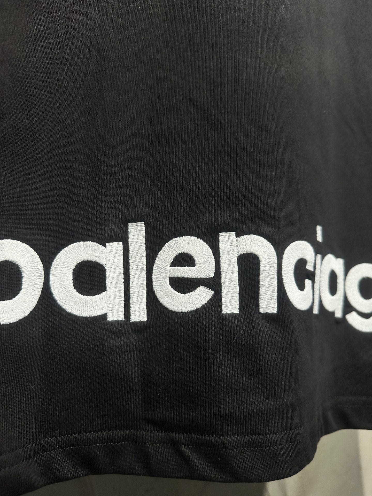 Black T-shirt with partial Balenciaga logo text at the lower hem