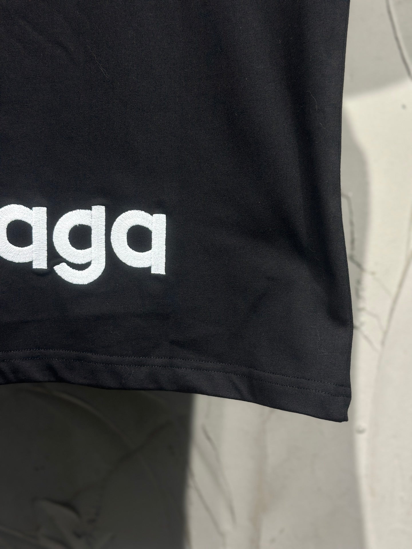 Black T-shirt with partial Balenciaga logo text near the side hem
