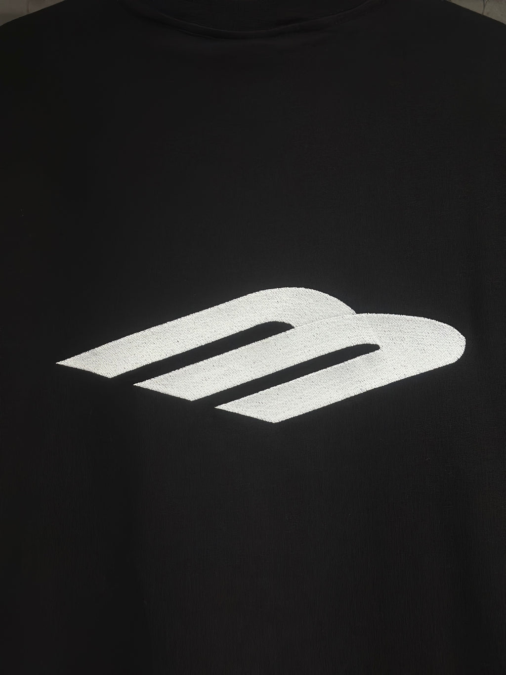 Black short-sleeve T-shirt with large white logo graphic on the chest