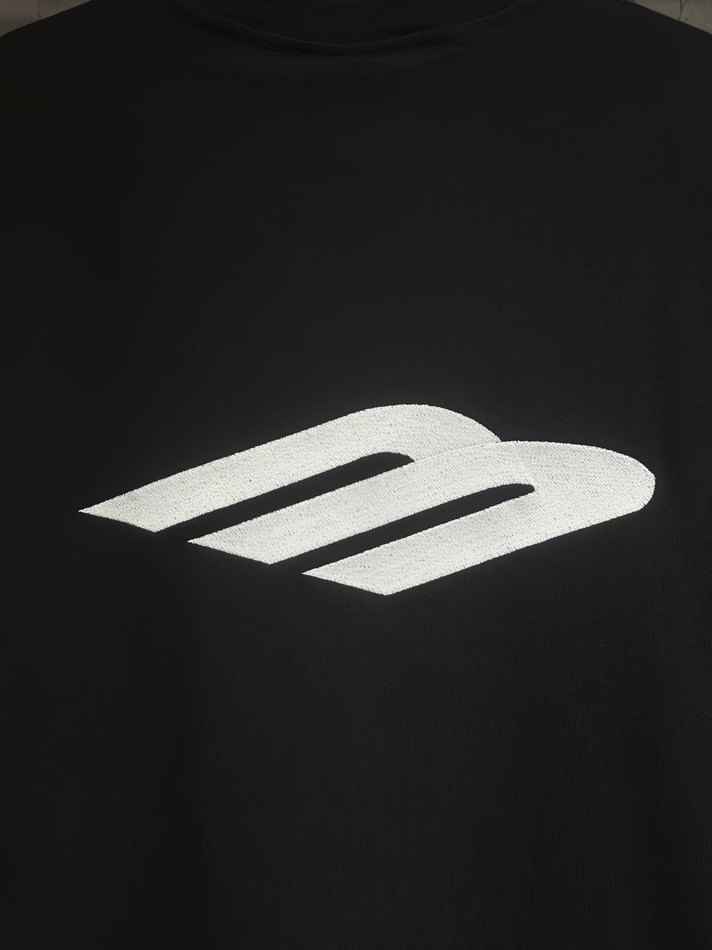 Black short-sleeve T-shirt with large white logo graphic on the chest