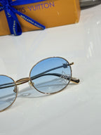 Louis Vuitton round sunglasses close-up with blue lenses and gold frame