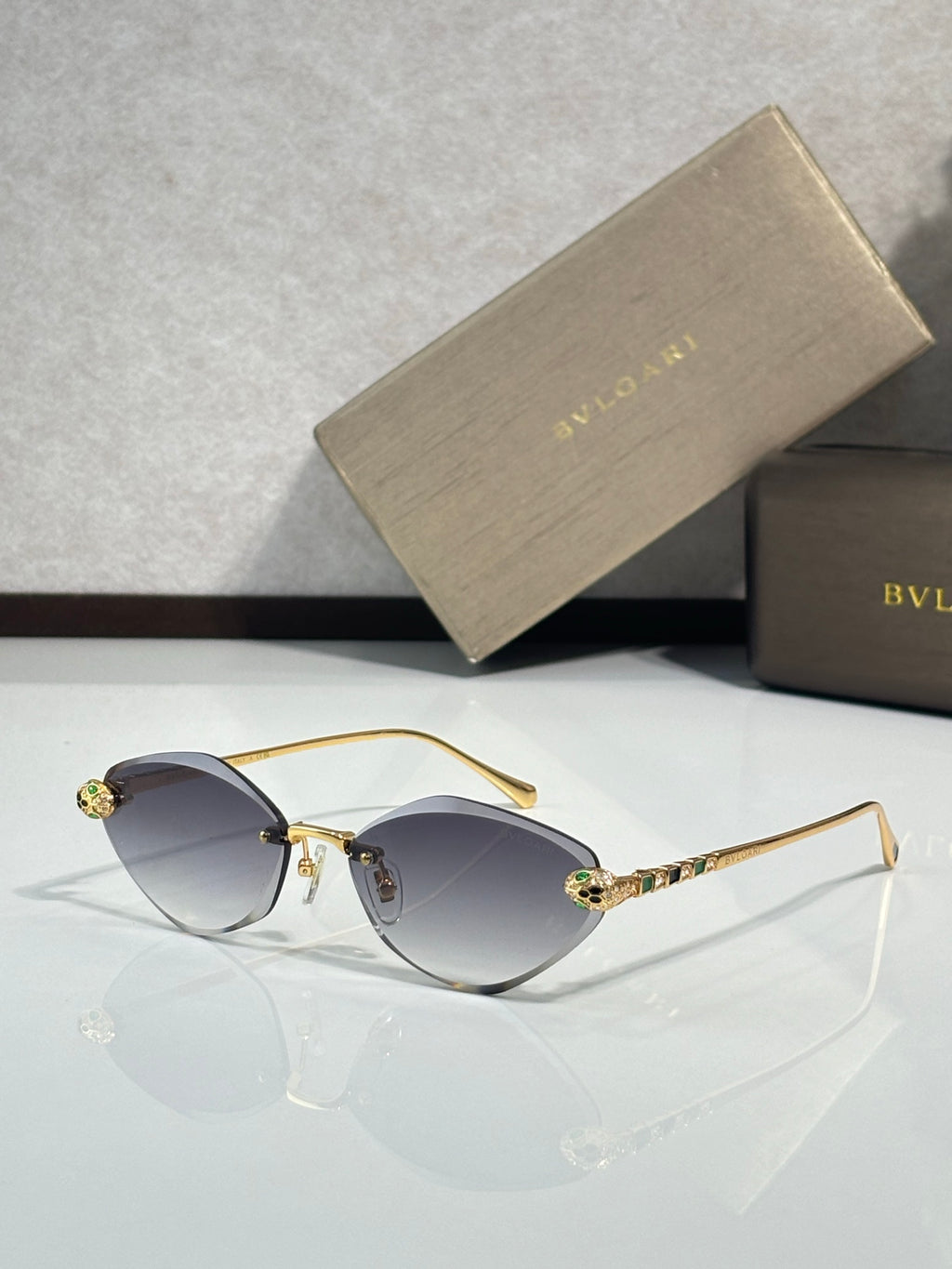 Bvlgari gold-tone sunglasses with dark gray gradient lenses and jeweled temple tips