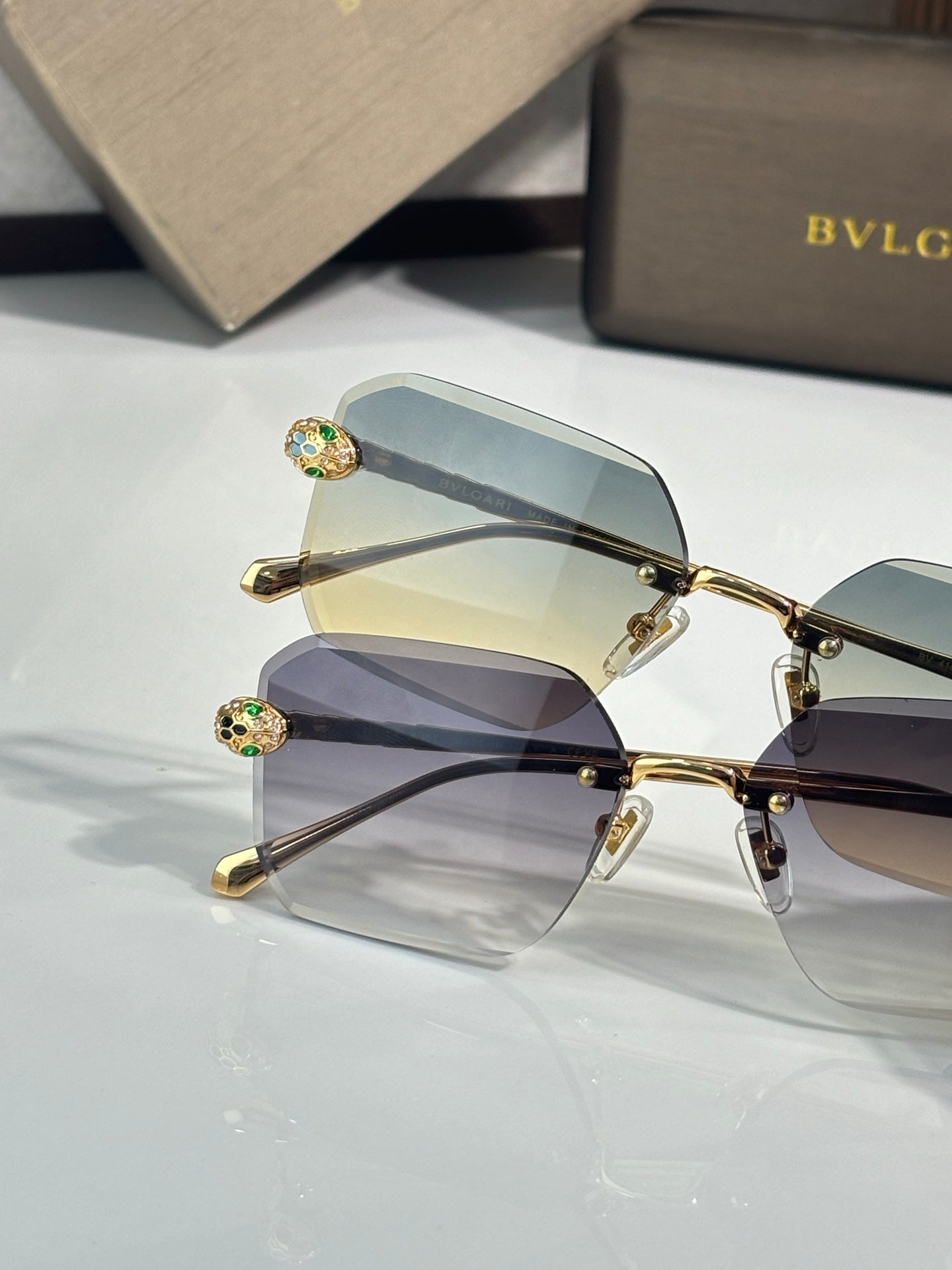 Bvlgari glasses, close view of gold metal rectangular frames with blue tinted lenses