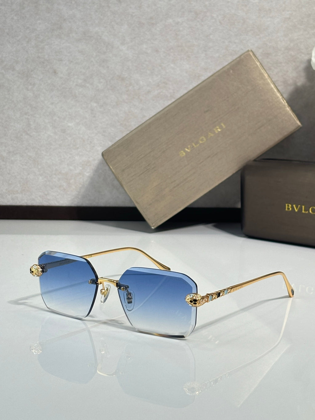Bvlgari glasses, gold metal rectangular frames with deep blue tinted lenses and jeweled temples