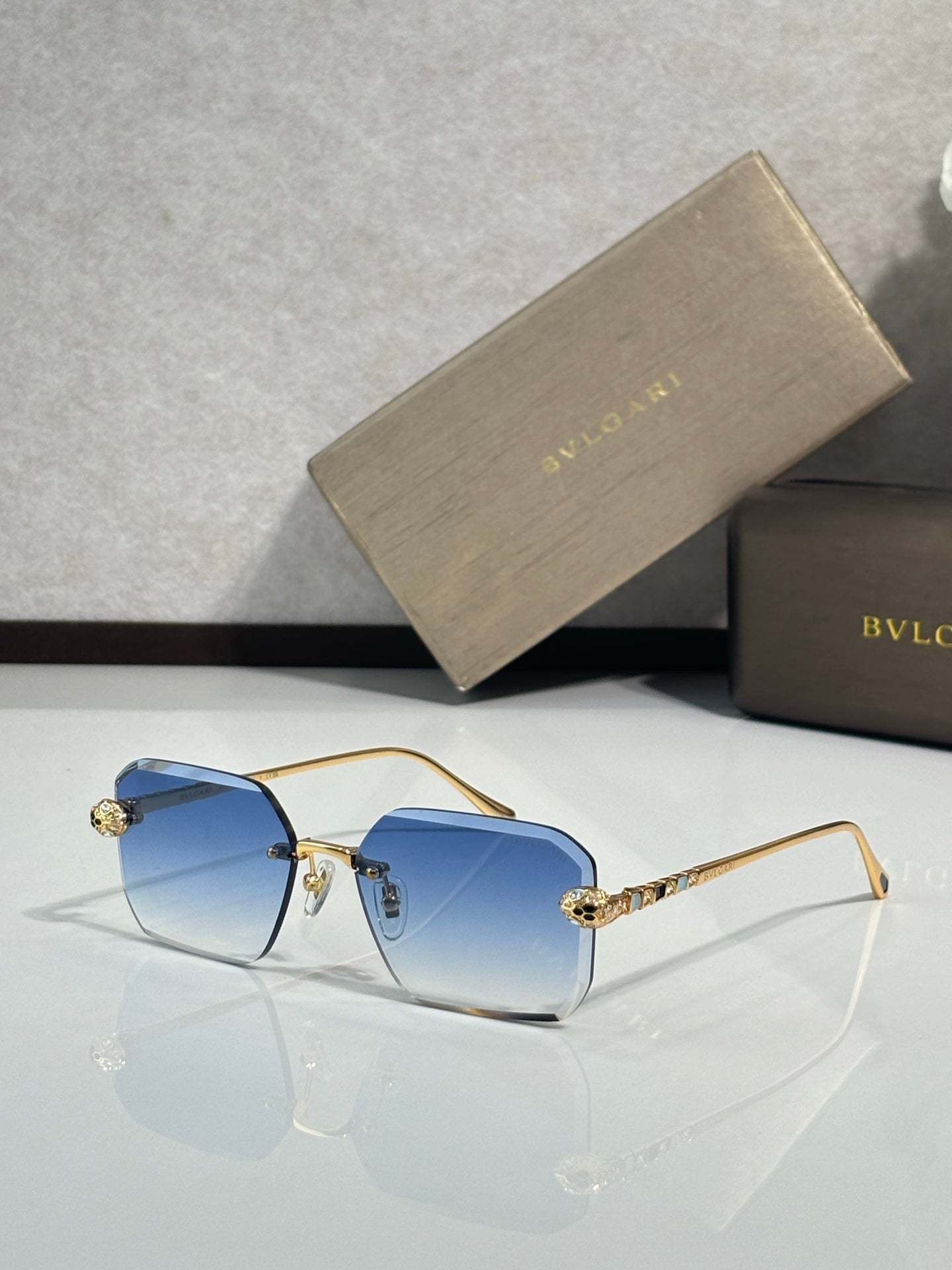 Bvlgari glasses, gold metal rectangular frames with deep blue tinted lenses and jeweled temples