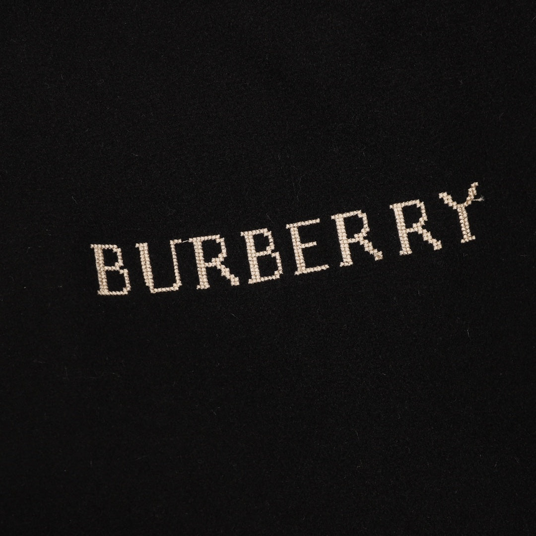 Burberry embroidered word logo on black fabric, close-up