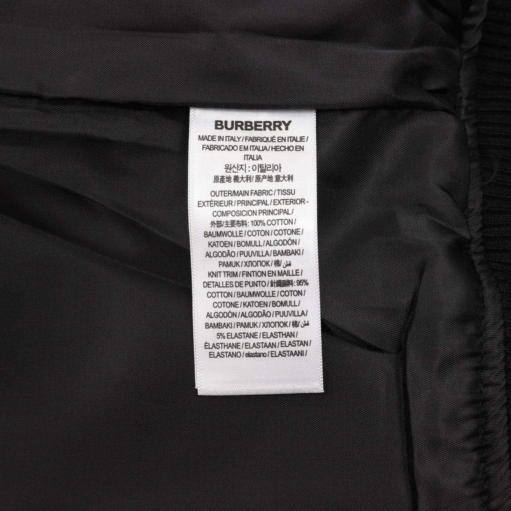 Burberry inner care label with material and country text on dark fabric