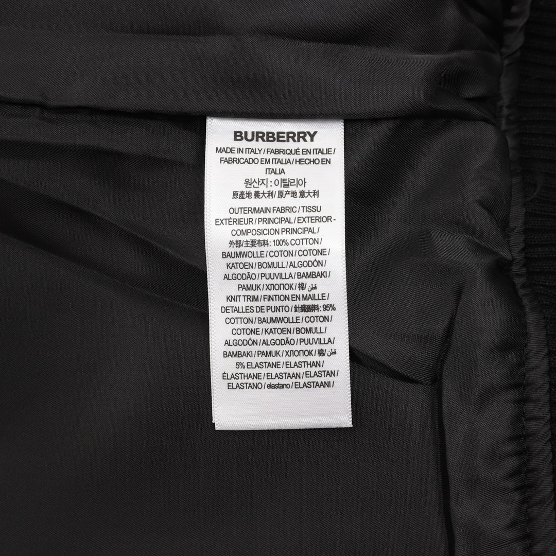 Burberry inner care label with material and country text on dark fabric