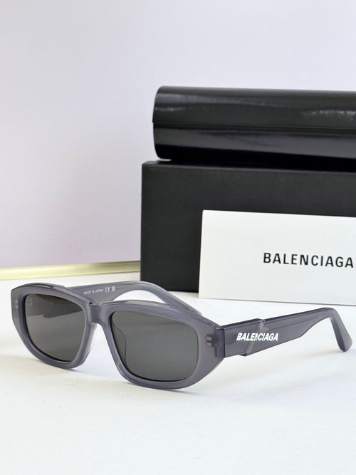 Gray sunglasses with dark lenses and Balenciaga logo on temple arms