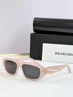 Light pink sunglasses with dark lenses and Balenciaga logo on temple arms