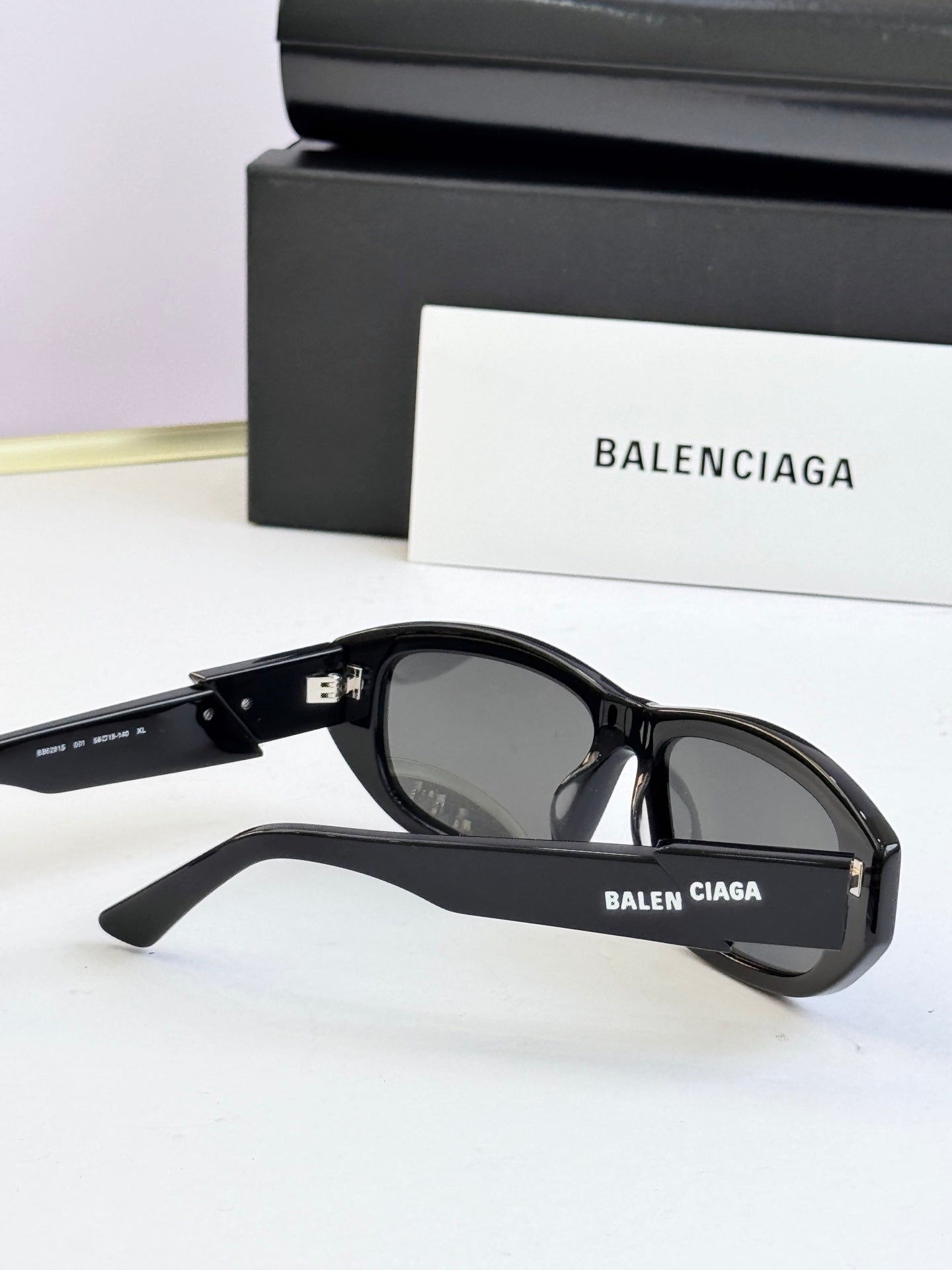 Black sunglasses with dark lenses and Balenciaga logo on side
