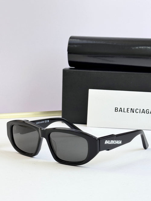 Black sunglasses with dark lenses and Balenciaga logo on temple arms
