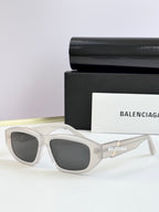 Clear sunglasses with dark lenses and Balenciaga logo on temple arms