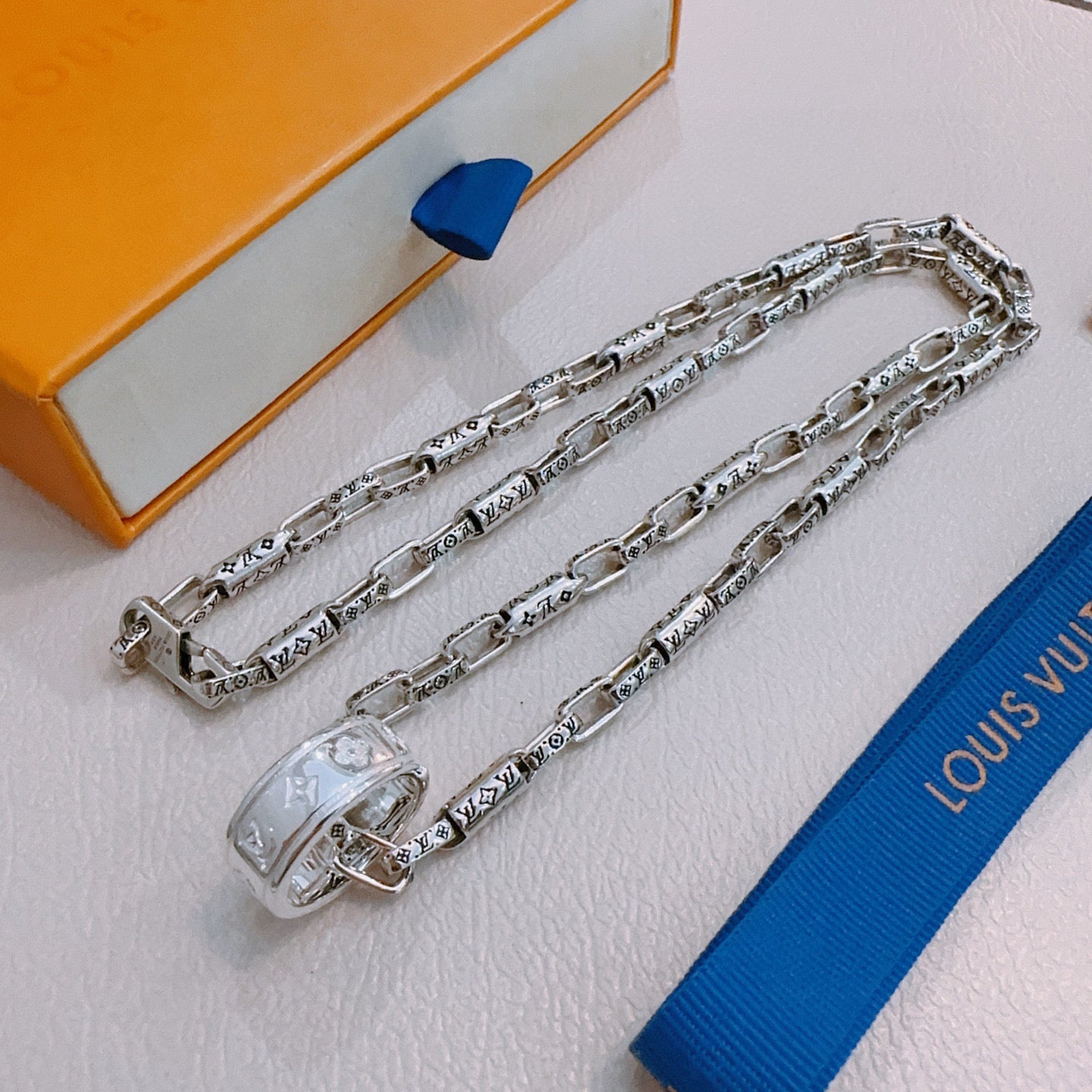 Silver chain necklace with clasp and engraved links, on jewelry card