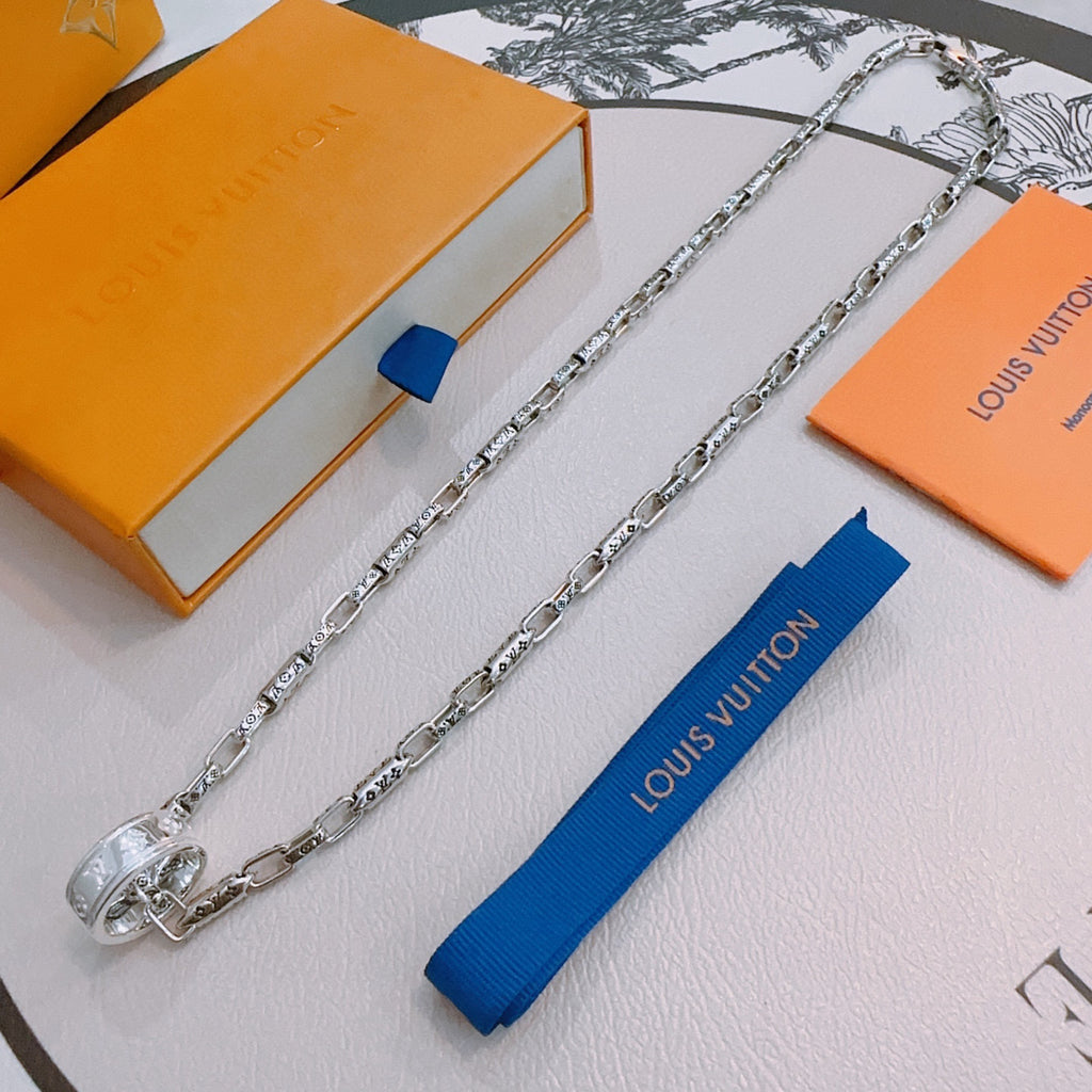 Silver chain necklace with charm clasp and engraved links, draped for display