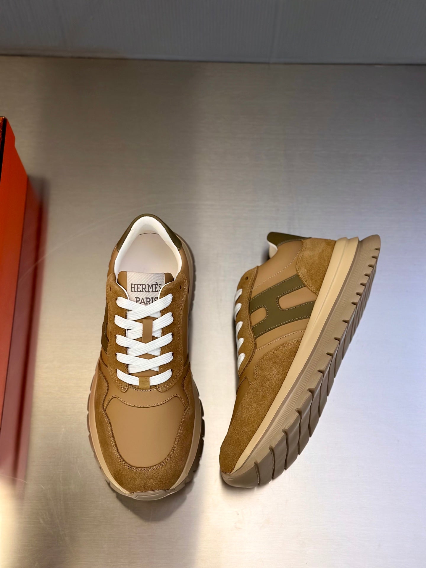 Tan sneakers with white laces and rubber sole, front and side view