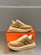 Brown and beige lace-up sneakers with white laces, side/front angle on box
