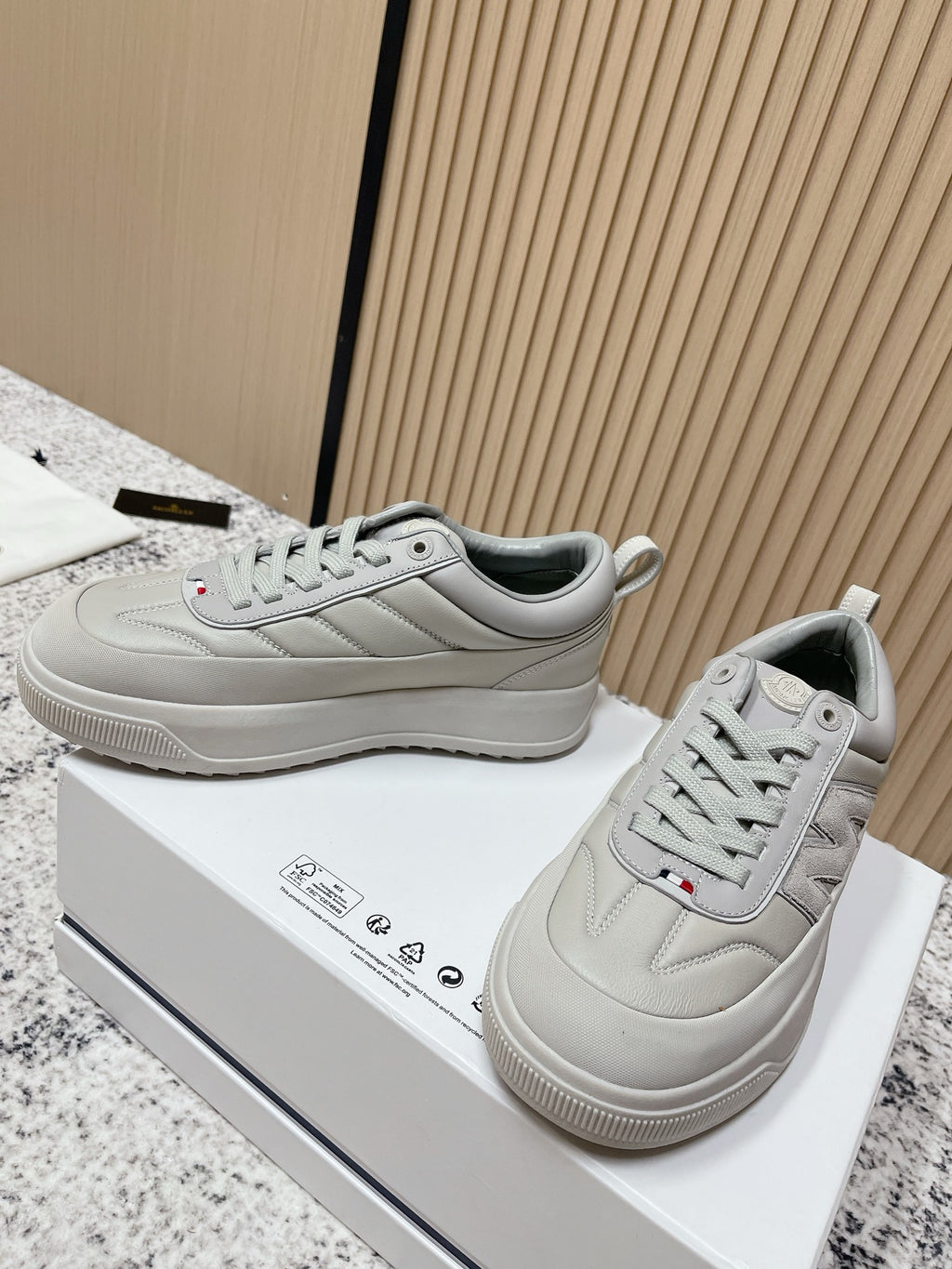Light gray lace-up sneakers with Moncler logo patch and textured rubber outsole