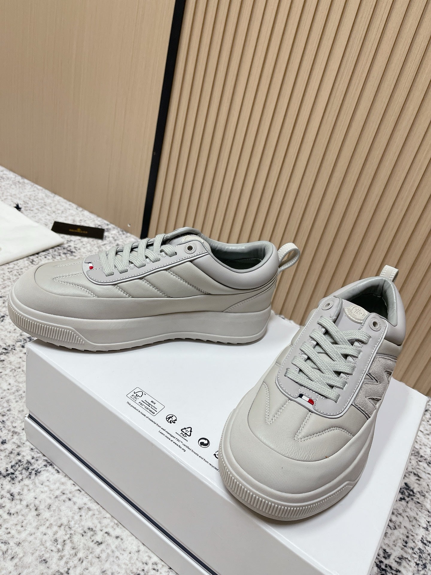 Light gray lace-up sneakers with Moncler logo patch and textured rubber outsole