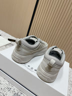 Light gray low-top sneakers with heel pull tabs and Moncler logo on back