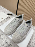 Light gray low-top sneakers with lace-up design and Moncler emblem on tongue