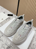 Light gray low-top sneakers with lace-up design and Moncler emblem on tongue
