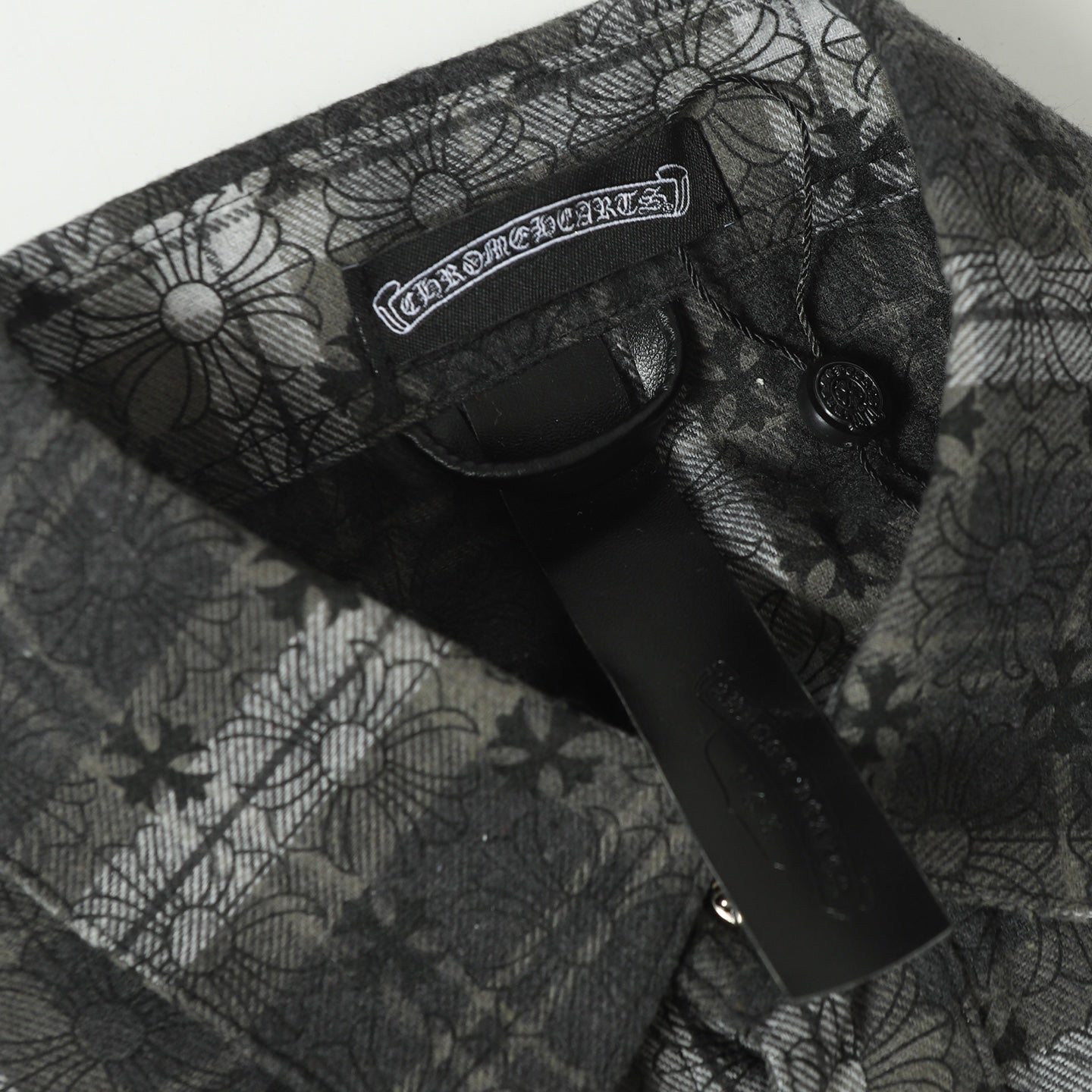 Dark gray patterned button-up shirt chest panel with label and buttons