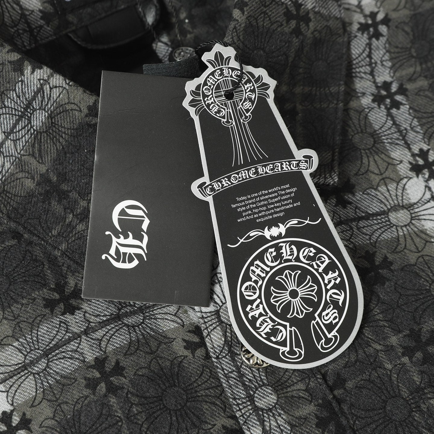 Dark gray button-up shirt packaging label and tag on patterned fabric