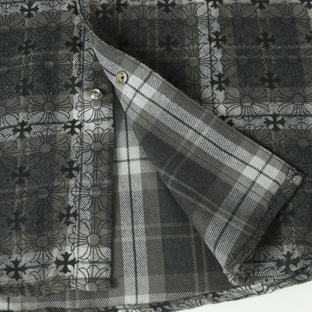 Dark gray button-up shirt sleeve with plaid inner facing and gold buttons
