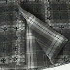 Dark gray button-up shirt sleeve with plaid inner facing and gold buttons