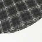 Dark gray floral-patterned button-up shirt hem with decorative trim