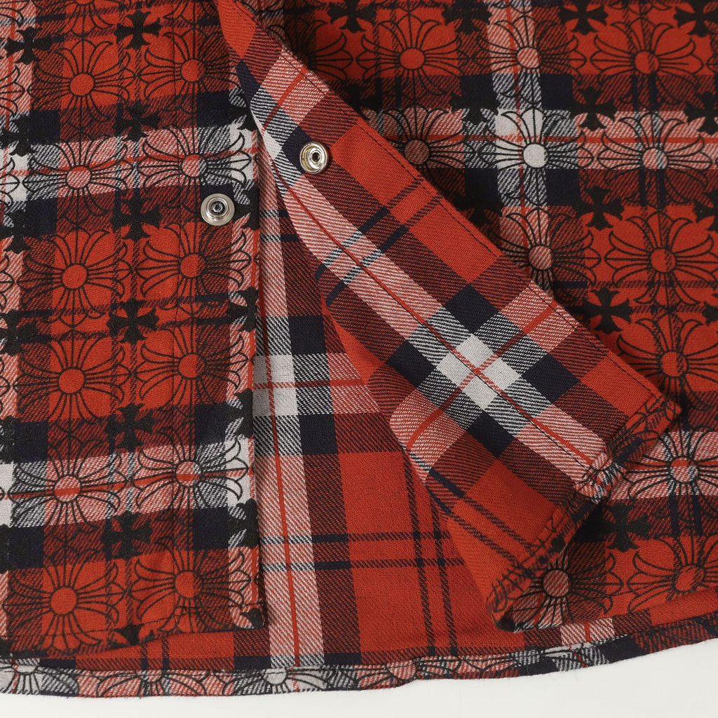 Long-sleeve shirt sleeve detail with red and white plaid and a silver snap button