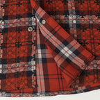 Long-sleeve shirt sleeve detail with red and white plaid and a silver snap button