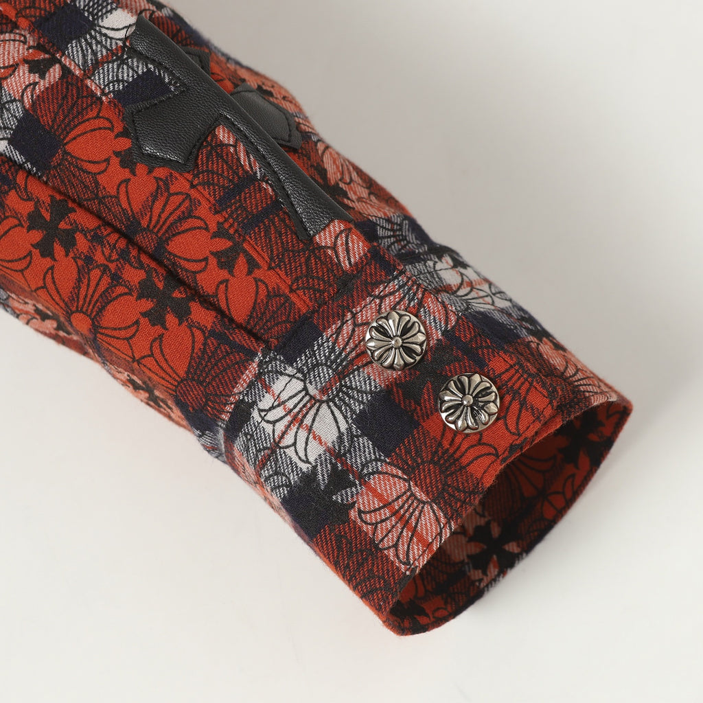 Long-sleeve shirt cuff with two silver-tone snap buttons on red floral plaid