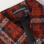 Long-sleeve shirt placket with black snap buttons on red floral plaid fabric
