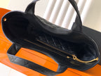 Black quilted tote bag interior view with zip pocket and gold chain