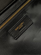 Black leather label on bag with gold 'SAINT LAURENT PARIS' text