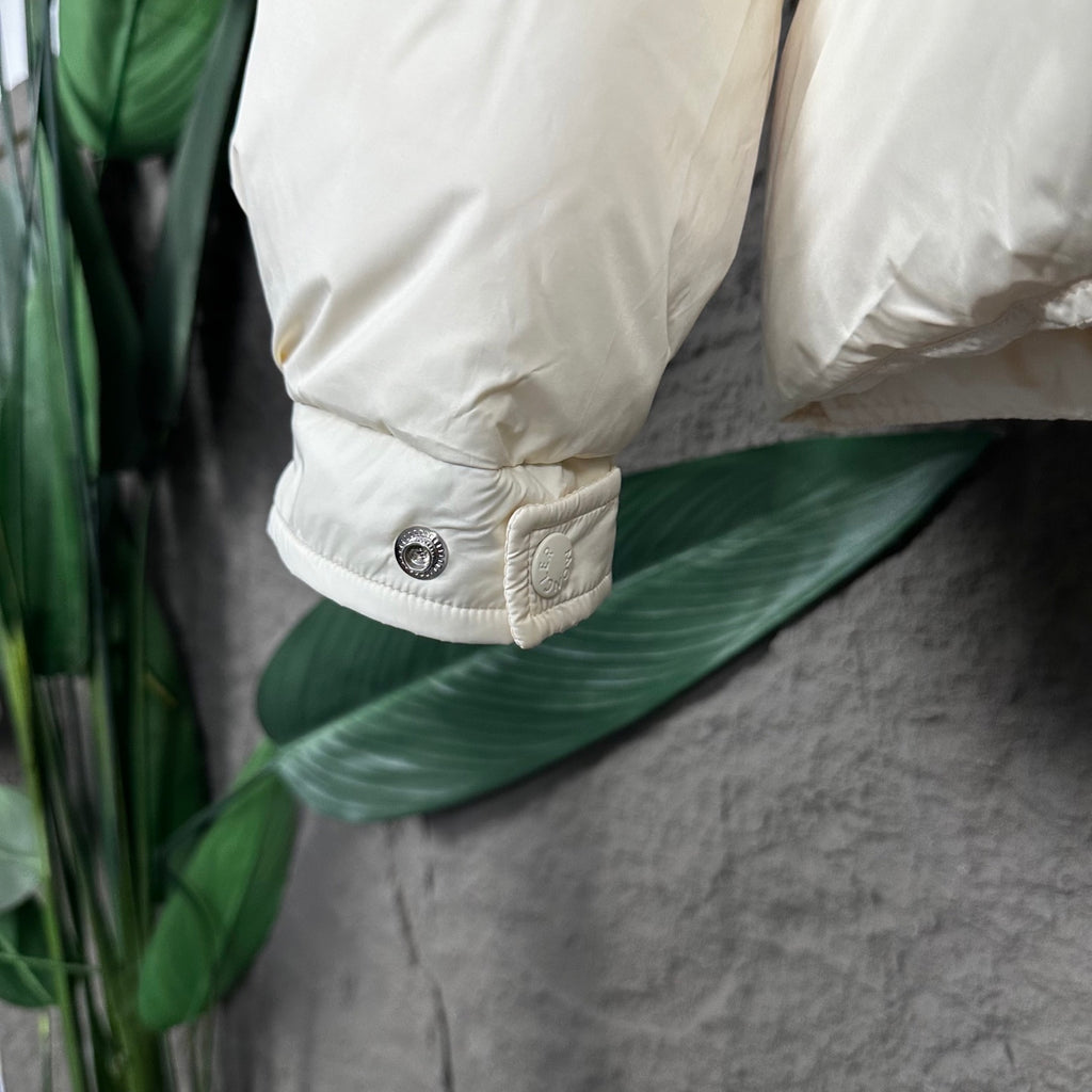 Off-white puffer jacket cuff with snap button and stitched detail