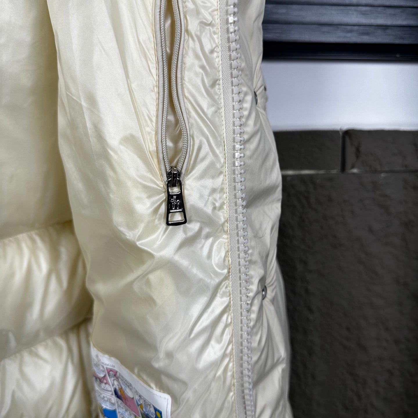 Off-white puffer jacket side with full zipper and snap placket