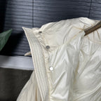 Off-white puffer jacket shoulder with textured quilting and snap buttons