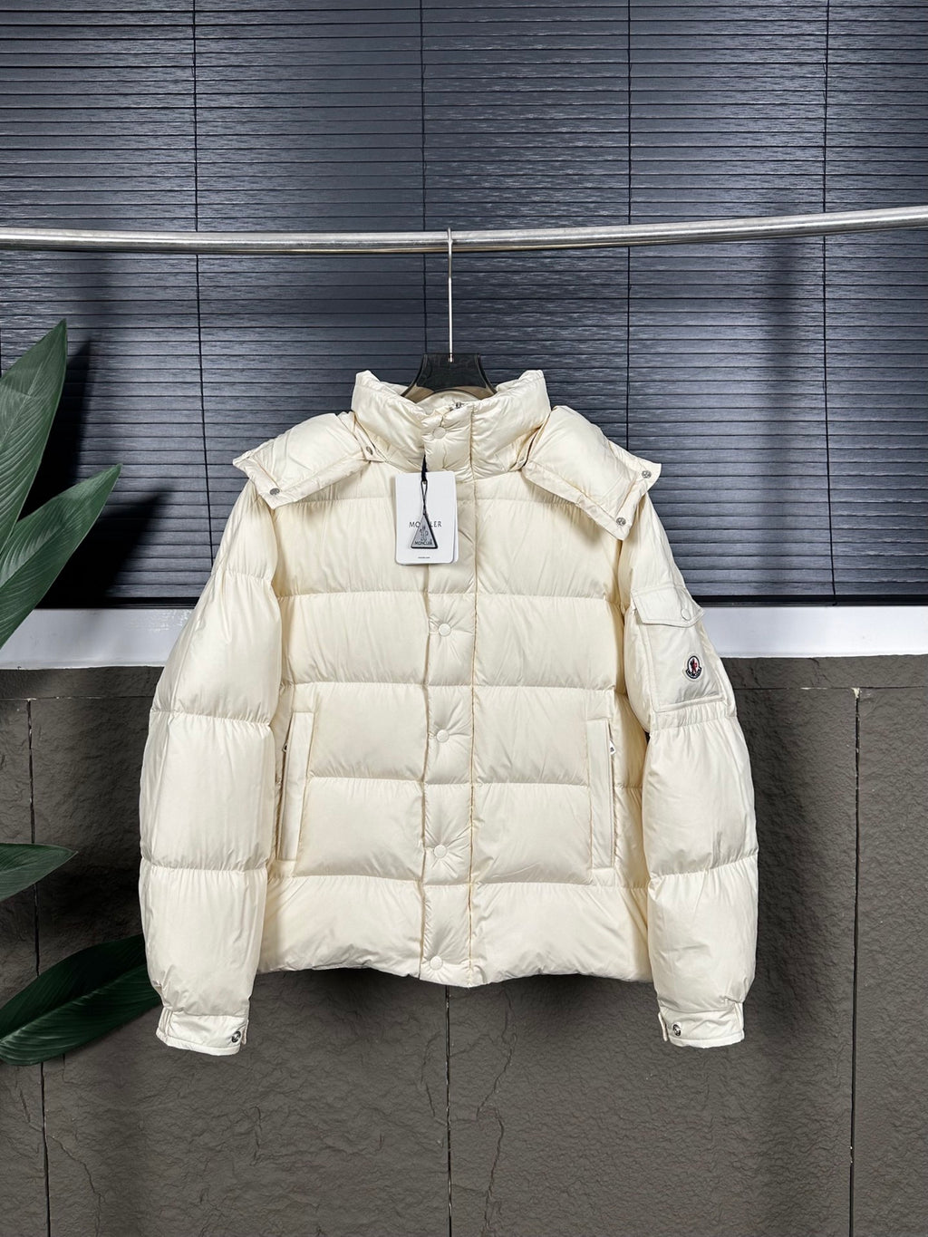 Long cream puffer jacket with quilted body, hood, and snap cuffs