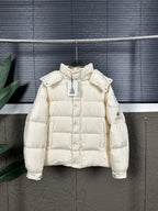 Long cream puffer jacket with quilted body, hood, and snap cuffs