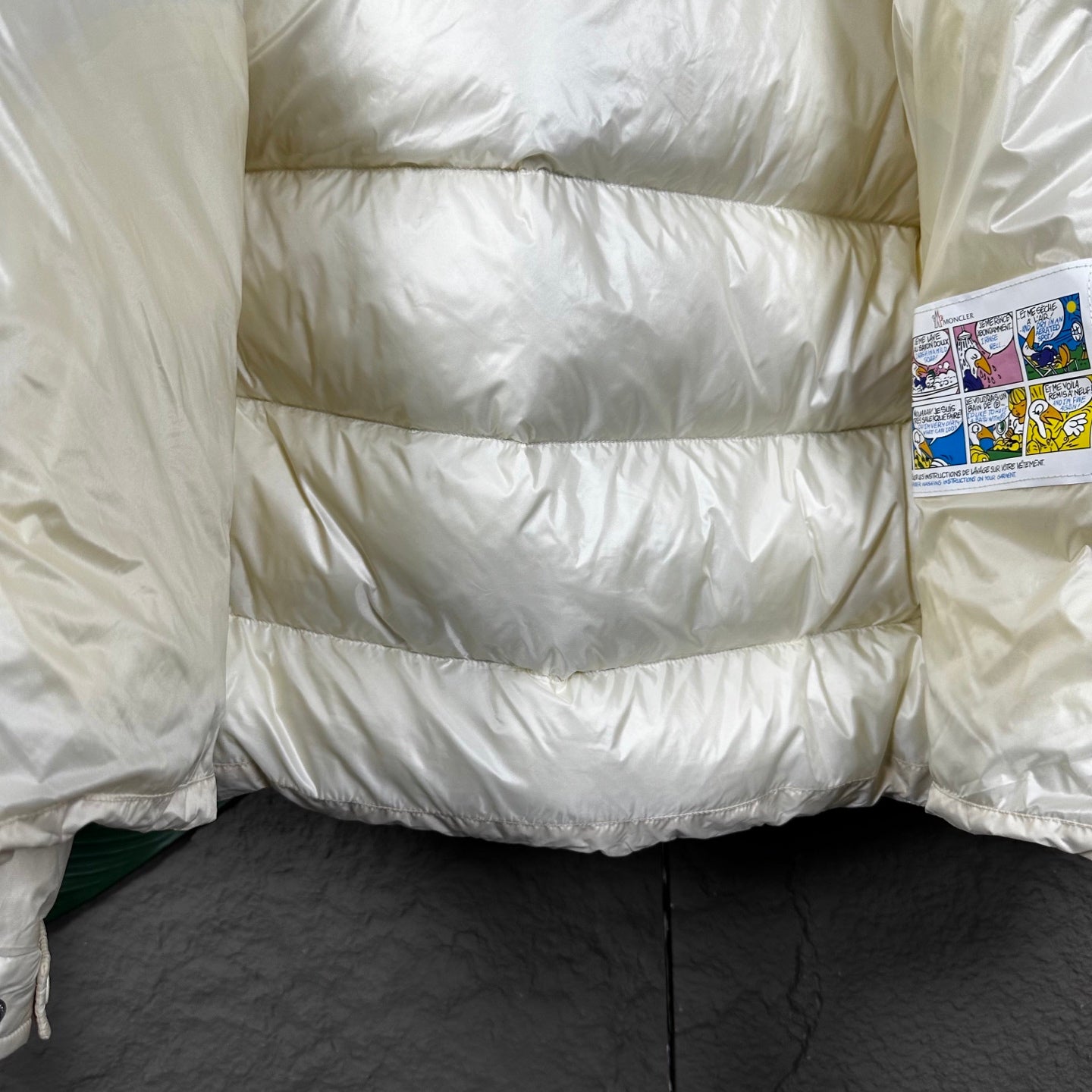 Long cream puffer jacket with horizontal quilted panels and zipper edge