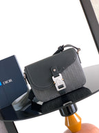 Crossbody bag with flap and silver-tone buckle, dark gray textured logo canvas