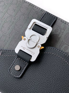 Close-up of crossbody bag strap buckle, dark gray logo fabric and leather patch
