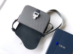 Crossbody bag flat lay with shoulder strap, dark gray logo canvas and leather trim