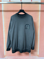 Dark teal long-sleeve sweatshirt with small chest graphic emblem